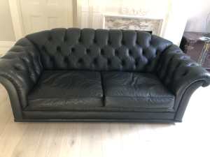 A pair of Moran 2 1/2 seater sofas in black leather