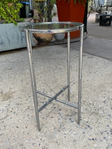 Round silver side table with glass top