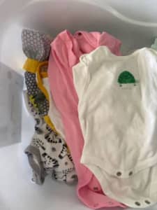 Selection of newborn girls clothes and bathtub