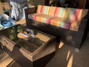 Outdoor wicker lounge and matching glass topped coffee table