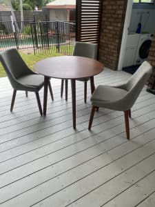 Round wooden table with three chairs