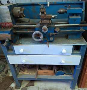 Metal Lathe 3 and 4 jaw chuck on stand with other accessories