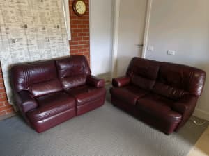 Twin set of burgandy leather sofas (one of which is a recliner)
