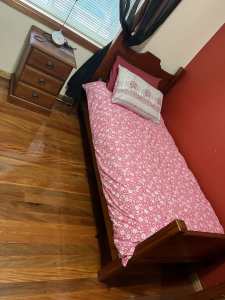 Single bed, mattress and bedside table.