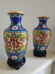 Chinese blossom decorated cloisonne vase on carved wood stand.