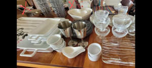 Heaps of glass, crockery, stainless steel, china serving dishes, trays