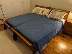 Two matching single sleigh beds with mattresses, timber slat base