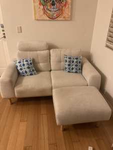 Stylish cream 2-seater sofa with footrest set.