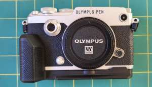 Olympus PEN-F digital camera in silver with hand grip