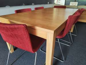 Timber dining table with red chairs