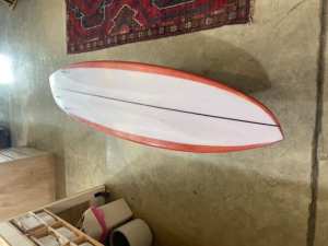 Asymmetric mid length surfboard