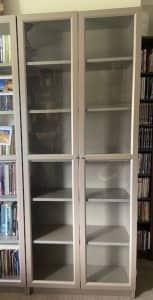 Ikea Billy book case with glass doors and grey metallic finish.