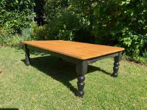 Rectangular rustic pine coffee table with black base and legs.