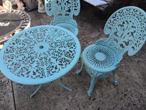 Cast iron table and two (2) chairs.