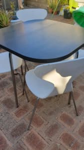 Wood grain table with 4 white chairs 