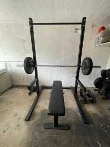 Squat rack with chin up bar, bench, barbell and bumper plates