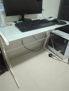 White Computer desk with glass top on a steel frame.