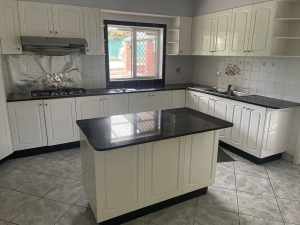 A full set of kitchen cabinets with a kitchen island