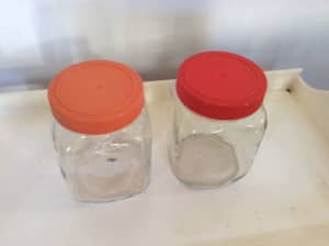 Two retro vintage glass jars with plastic lids red and orange