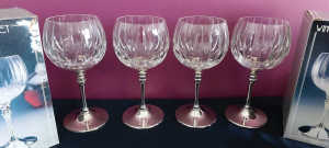 4 crystal wine glasses on silver stems. As new in original boxes