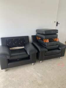 TWO BLACK LEATHER ARMCHAIRS & MATCHING OTTOMANS