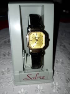 Sabre ladies womens gold tone watch with black leather band.New in box
