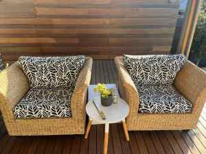 Two woven chairs with outdoor cushions