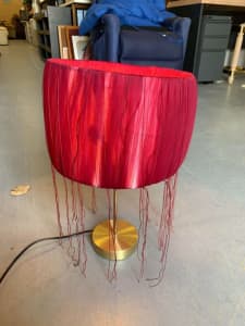 Pretty lamp with a dark pink shade with tassels 