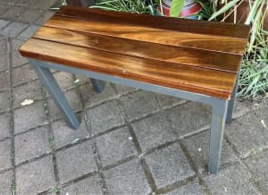 Wooden seat stool short bench on metal frame. Plant stand Pool