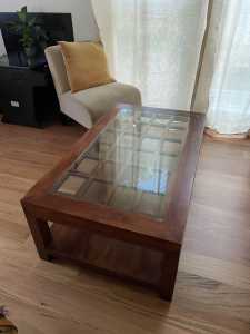 Solid timber coffee table with shelf and glass top.