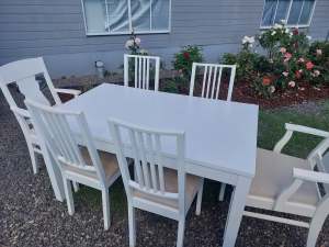 White extendable dining table with six chairs