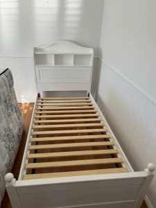 Bed, storage area with shelves and a king single Sealy mattress