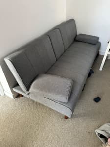 Sofa couch that folds down, grey fabric, timber legs