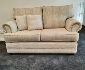 Two seater cream brocade sofa