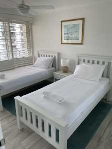 Two single beds - white open post bed frame 