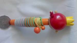 Colourful, fun elastics wound around a brightly painted wooden doll