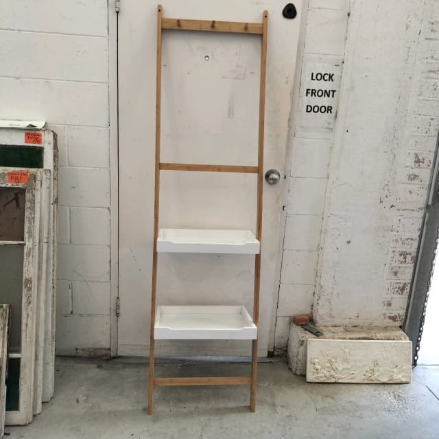 Against the wall leaning timber and white shelving unit with hooks
