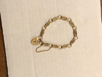 Star Lot : A pretty nine carat gold (375) three bar gate bracelet with pad  lock clasps and safety ch